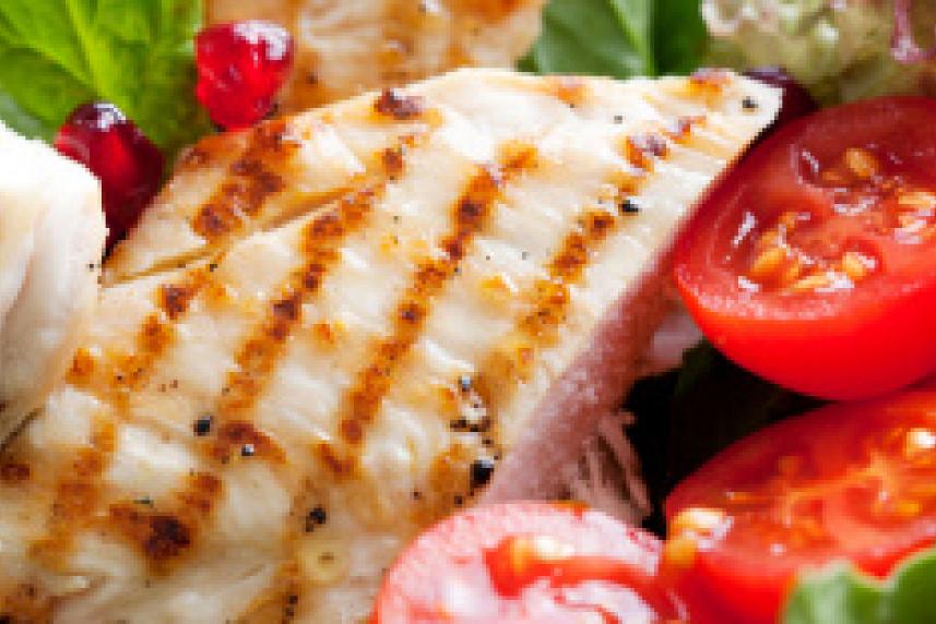 A salad with avocado, chicken, cherry tomatoes and other veggies
