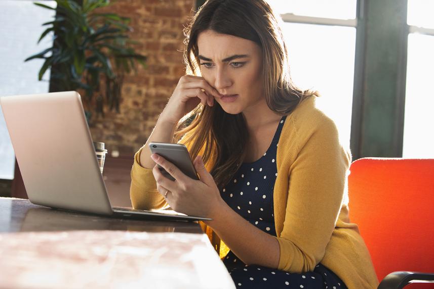 Woman on her phone feeling stressed and anxious