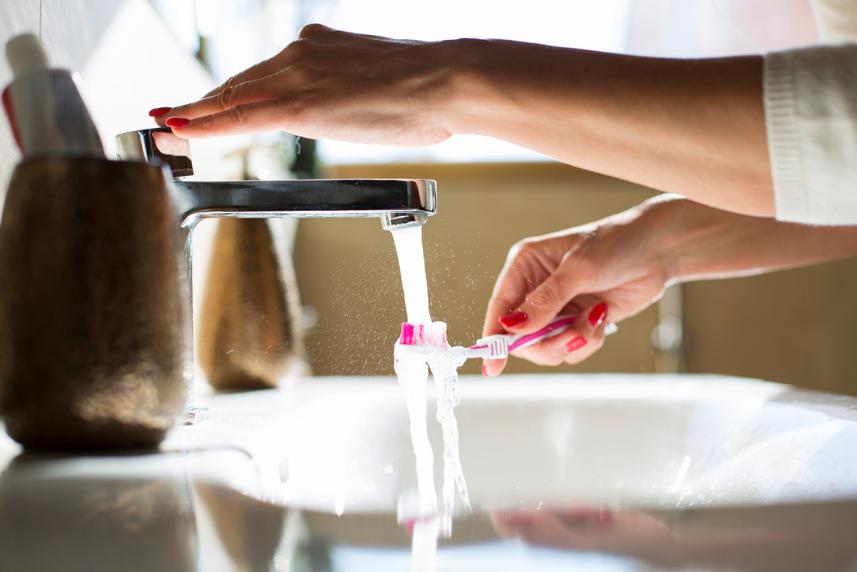 Woman washing her toothbrush